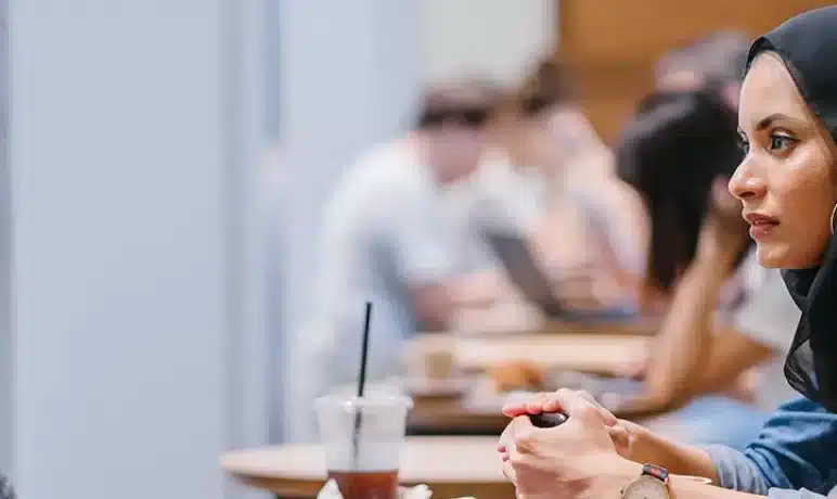 vrouw met hoofddoek samen in gesprek met ander vrouw aan tafeltje
