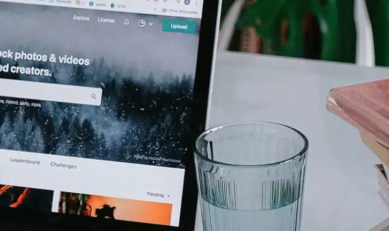 laptop scherm tikkende hand glas water huiselijke omgeving