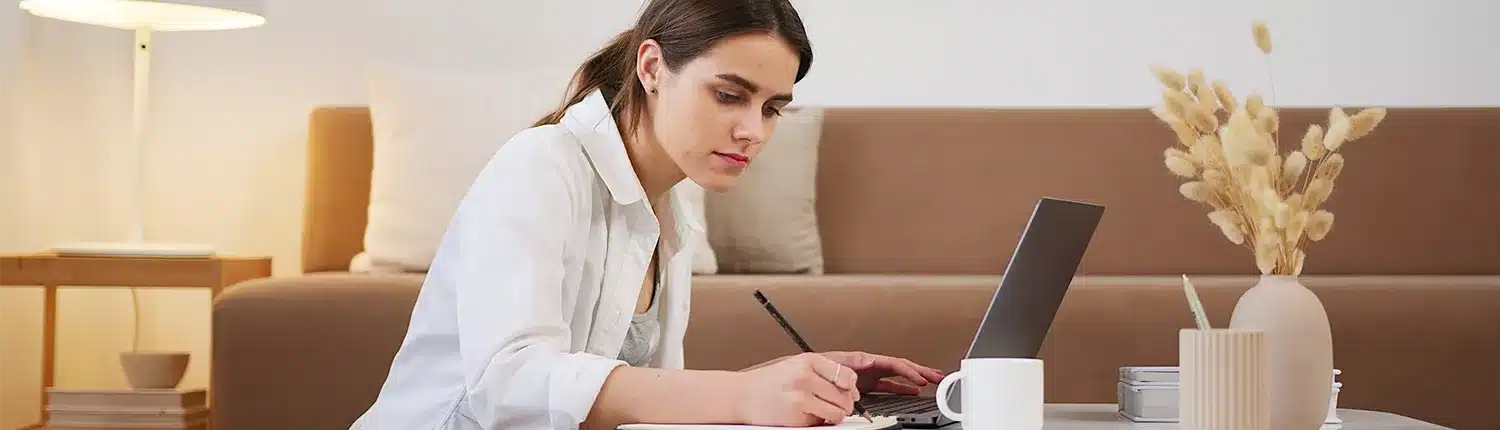 vrouw werkend met laptop, koffie schrijvend aan koffietafel