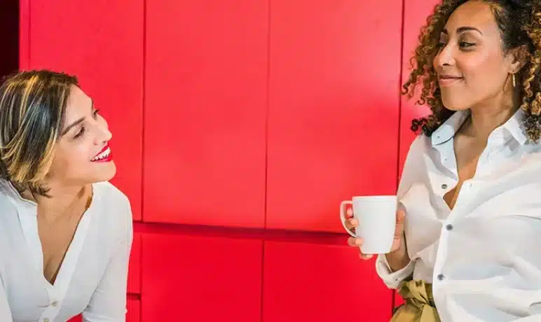twee vrouwen in gesprek met kopje in de hand