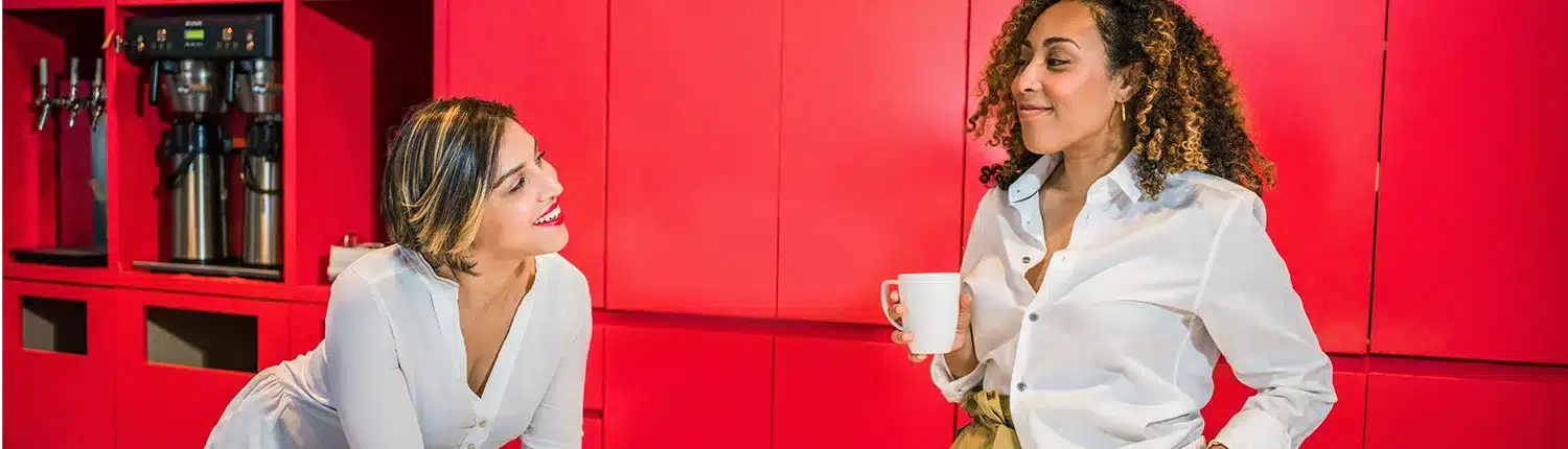 twee vrouwen in gesprek met kopje in de hand