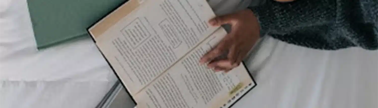 bovenaanzicht open geslagen boek met hand