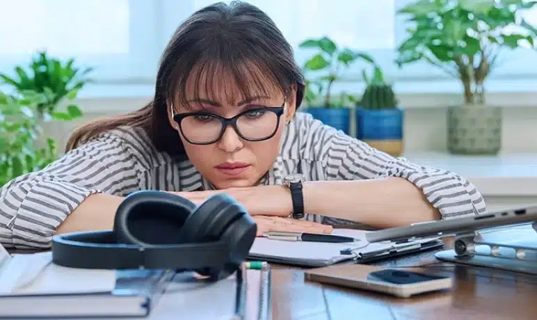 vermoeide vrouw die op haar bureau ligt