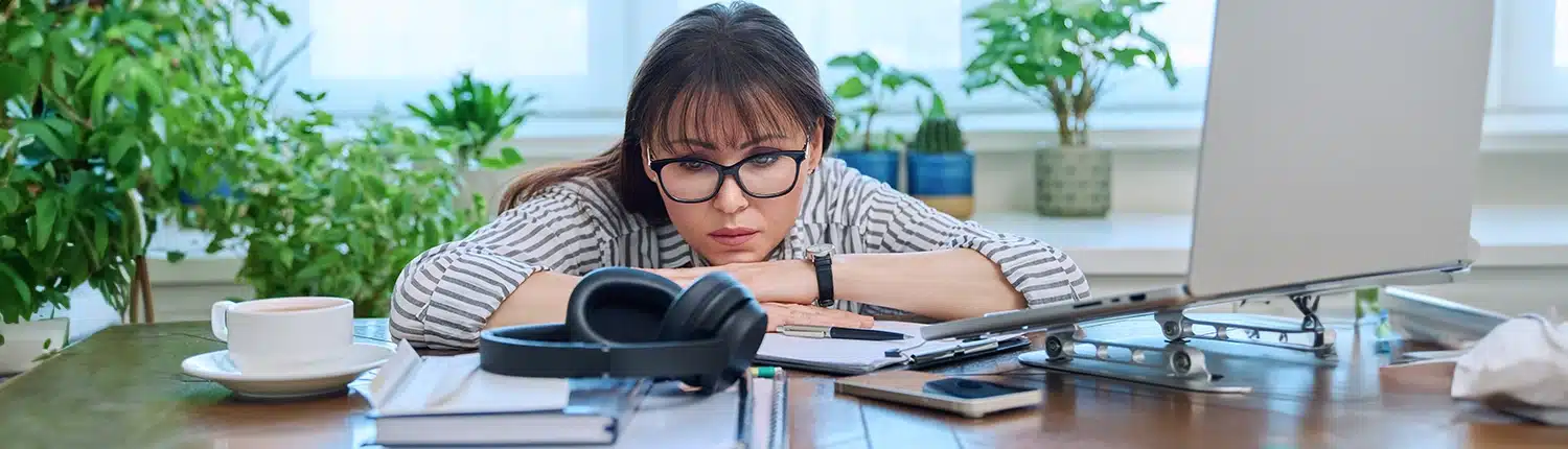 vermoeide vrouw die op haar bureau ligt