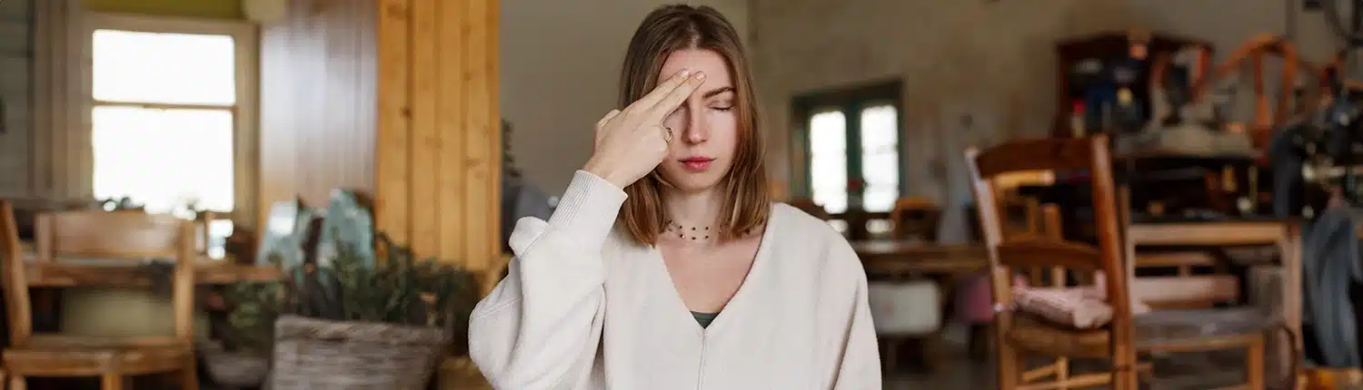 Vrouw die 2 vingers op haar hoofd houdt