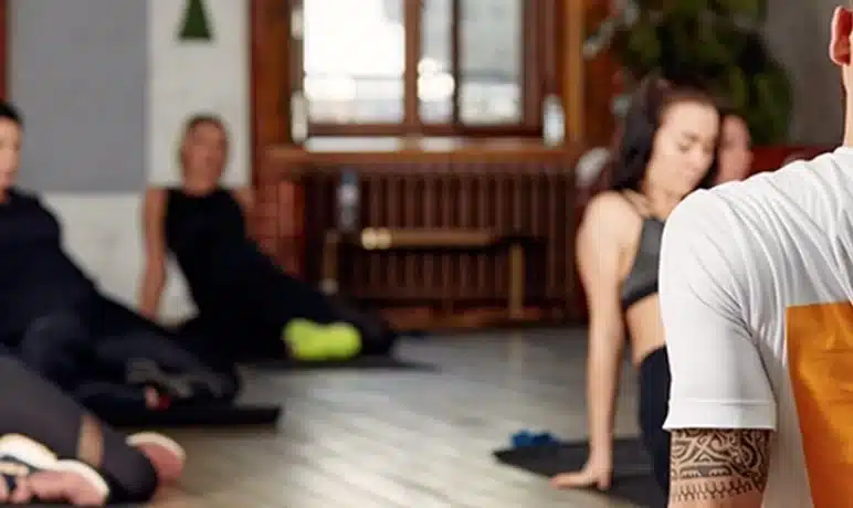 Man die een Yogatraining geeft voor een groep